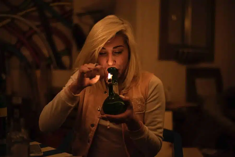 woman firing up a homemade bong