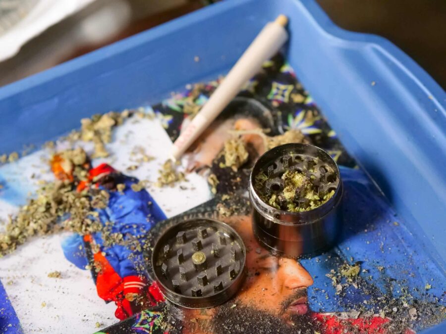 Weed grinder and flower on a tray to enhance the flavor of weed
