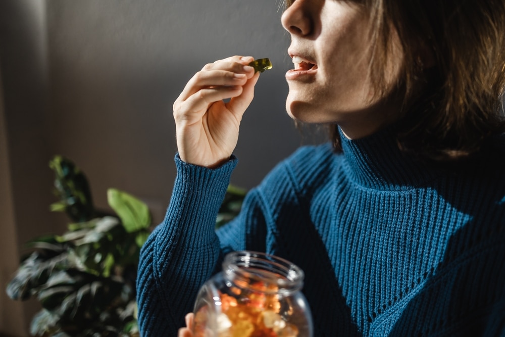 woman taking cannabis gummies for anxiety