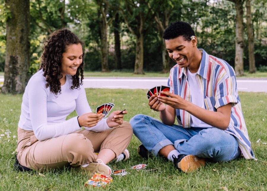couple playing cards outdoors while high